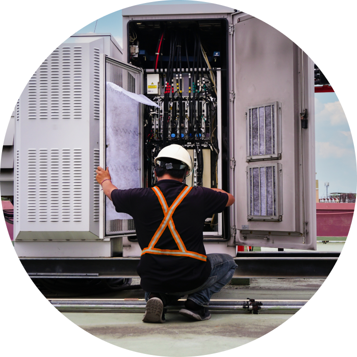 A telecommunications technician working on equipment